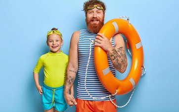 Mann mit Rettungsring und Kind mit Schwimmbrille