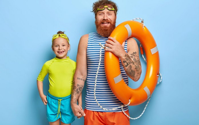 Mann mit Rettungsring und Kind mit Schwimmbrille