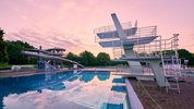 Sprungturm mit Wasserrutsche im Hintergrund