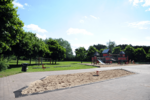 Spielplatz mit Holzhaus, Wiese und Sandkasten