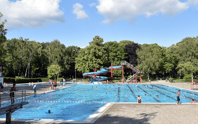 Badegäste im Schwimmbecken mit Rutsche