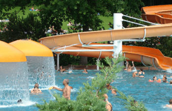 Badegäste im Schwimmbecken mit Rutsche